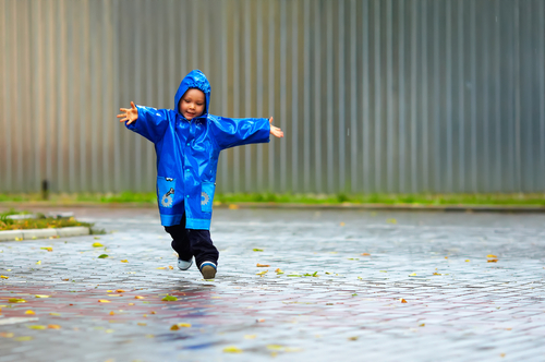 A boy running through the rain.